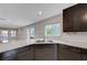 Bright kitchen with granite counters, stainless steel dishwasher, and dark wood cabinets at 7052 Blissful Peak St, North Las Vegas, NV 89084