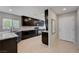 Modern kitchen features granite countertops, stainless steel appliances, and dark cabinets, complete with a view of the exterior at 7052 Blissful Peak St, North Las Vegas, NV 89084