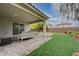 Covered patio with neutral furnishings and brick pavers overlooks a charming yard at 7052 Blissful Peak St, North Las Vegas, NV 89084