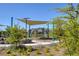 Playground with shade canopies, climbing structure, and manicured shrubs in a community park at 7052 Blissful Peak St, North Las Vegas, NV 89084