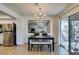 Bright dining area with modern light fixture, table with benches, and stainless appliances at 718 Nectarine Ct, Henderson, NV 89014