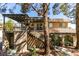 Two-story townhouse exterior with wood staircase leading to large balcony deck above the landscaped front yard at 718 Nectarine Ct, Henderson, NV 89014