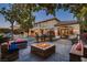 A backyard oasis with a fire pit, lounge seating, manicured landscaping, and a sparkling pool at 7501 Midnight Rambler St, Las Vegas, NV 89149