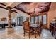 Formal dining room with custom ceiling art, stone accent wall, and elegant chandelier for luxurious dining at 7501 Midnight Rambler St, Las Vegas, NV 89149