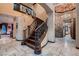 Grand foyer with curved staircase, stone accents, and chandelier, creating a stunning first impression at 7501 Midnight Rambler St, Las Vegas, NV 89149