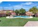 Inviting backyard featuring a swimming pool, spa, and artificial grass area for outdoor enjoyment at 7545 Fontera Ct, Las Vegas, NV 89139