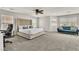 Spacious main bedroom with a large bed, seating area, ceiling fan, and natural light at 7545 Fontera Ct, Las Vegas, NV 89139