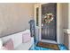 Up-close view of the front door with a floral wreath, a welcome sign, and an outdoor bench at 7545 Fontera Ct, Las Vegas, NV 89139