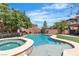 Sparkling backyard pool and spa with basketball hoop, mature trees and lush synthetic lawn at 7545 Fontera Ct, Las Vegas, NV 89139