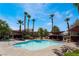 Community pool featuring lounge chairs, shade coverings, and mature palm trees in the Rancho Viejo Community at 7885 W Flamingo Rd # 1161, Las Vegas, NV 89147