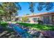 Backyard featuring running stream with lush greenery, mature trees and patio space at 7911 Canoe Ln, Las Vegas, NV 89145