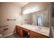 Bathroom featuring dual sinks, a large mirror, and wood-look laminate flooring at 7911 Canoe Ln, Las Vegas, NV 89145