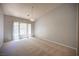 Spacious bedroom featuring neutral carpet, light fixture and large window at 7911 Canoe Ln, Las Vegas, NV 89145