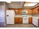 Well-lit kitchen featuring wood cabinets, modern appliances, and sleek laminate flooring at 7911 Canoe Ln, Las Vegas, NV 89145