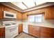 Well-lit kitchen featuring wood cabinets, modern appliances, and sleek laminate flooring at 7911 Canoe Ln, Las Vegas, NV 89145