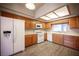Well-lit kitchen featuring wood cabinets, modern appliances, and sleek laminate flooring at 7911 Canoe Ln, Las Vegas, NV 89145