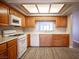 Well-lit kitchen featuring wood cabinets, modern appliances, and sleek laminate flooring at 7911 Canoe Ln, Las Vegas, NV 89145
