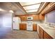 Well-lit kitchen featuring wood cabinets, modern appliances, and sleek laminate flooring at 7911 Canoe Ln, Las Vegas, NV 89145