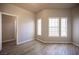Sunlit living room with large windows, laminate flooring, and neutral paint at 7911 Canoe Ln, Las Vegas, NV 89145