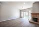 Spacious living room featuring hardwood floors, neutral paint, a fireplace and sliding glass door leading to the backyard at 7911 Canoe Ln, Las Vegas, NV 89145
