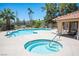 The community pool area showcasing a spa and covered lounging with table, chairs and picnic table at 7911 Canoe Ln, Las Vegas, NV 89145