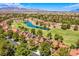 Community aerial view featuring golf course, lake, and housing in lush, green surroundings at 7940 Castle Pines Ave, Las Vegas, NV 89113