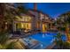 An exquisite backyard with a pool, patio, and beautiful landscaping at twilight at 7940 Castle Pines Ave, Las Vegas, NV 89113