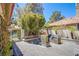 A cozy backyard patio area with an outdoor seating area and flowering plants at 7940 Castle Pines Ave, Las Vegas, NV 89113
