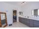 Elegant bathroom featuring double sinks, modern gray cabinetry, and access to a spacious walk-in closet at 7940 Castle Pines Ave, Las Vegas, NV 89113