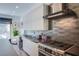 Kitchen with stainless steel appliances, range hood, modern backsplash, and sleek countertops at 7940 Castle Pines Ave, Las Vegas, NV 89113