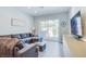 Comfortable living room with a gray sectional sofa, sliding glass doors to outdoor patio, and modern decor at 7940 Castle Pines Ave, Las Vegas, NV 89113
