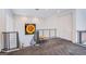 Open loft area with gray carpet, staircase, iron railing, and a sunflower art piece on the wall at 7940 Castle Pines Ave, Las Vegas, NV 89113