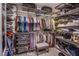 Bright walk-in closet featuring extensive shelving, hanging racks, and a comfortable seating stool at 7940 Castle Pines Ave, Las Vegas, NV 89113