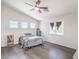Bright bedroom with high ceilings, wood-look flooring, and multiple windows at 7964 Lovely Pine Pl, Las Vegas, NV 89143