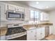 Modern kitchen featuring stainless steel appliances, granite countertops, and ample cabinet space at 7964 Lovely Pine Pl, Las Vegas, NV 89143