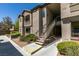 Exterior of a two story condo with an outdoor staircase, greenery and a blue sky in the background at 8250 N Grand Canyon Dr # 2001, Las Vegas, NV 89166