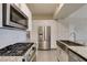 Modern kitchen featuring white cabinetry, granite countertops, stainless steel appliances and a large sink at 8250 N Grand Canyon Dr # 2001, Las Vegas, NV 89166