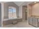 Bright bathroom featuring a soaking tub under a large window and a separate shower at 8300 Slate Harbor Cir, Las Vegas, NV 89128