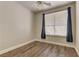Neutral bedroom featuring wood floors, window with blinds, and natural light at 8300 Slate Harbor Cir, Las Vegas, NV 89128
