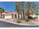 A single-story home with well-manicured landscaping and a two-car garage at 8300 Slate Harbor Cir, Las Vegas, NV 89128