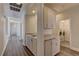 Hallway with laundry room featuring granite countertops, cabinetry, and modern appliances at 8300 Slate Harbor Cir, Las Vegas, NV 89128