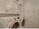Laundry room featuring modern appliances, overhead cabinets and chandelier lighting at 8300 Slate Harbor Cir, Las Vegas, NV 89128