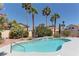Sparkling swimming pool surrounded by lush landscaping and palm trees creates a backyard paradise at 8300 Slate Harbor Cir, Las Vegas, NV 89128