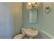 Powder room featuring a pedestal sink and a decorative mirror with lighting at 8300 Slate Harbor Cir, Las Vegas, NV 89128