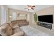 Inviting living room featuring a sectional sofa, ceiling fan, and ample natural light at 8335 Martinborough Ave, Las Vegas, NV 89131