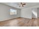 Bright bedroom featuring wood-look floors, a ceiling fan, and a window at 8396 Pearl Beach Ct, Las Vegas, NV 89139