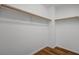 A walk-in closet with wood-look flooring and ample storage space with wooden hanging bars at 8396 Pearl Beach Ct, Las Vegas, NV 89139