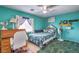 Bedroom with a wooden desk, tropical themed bedding, and a window with curtains at 8516 Canyon Ranch St, Las Vegas, NV 89131