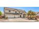 Two-story home with a three-car garage and manicured landscaping on a sunny day at 8516 Canyon Ranch St, Las Vegas, NV 89131