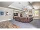 Open-concept living room with fireplace, ceiling fan, hardwood floors, and large comfy couch at 8516 Canyon Ranch St, Las Vegas, NV 89131